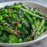 Colorful Spring Green Bowl featuring tender green beans, asparagus tips, and baby spinach tossed with a zesty lemon dressing.