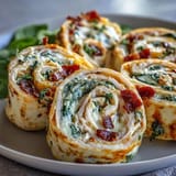 Bite-sized Turkey, Cheese & Spinach Tortilla Pinwheels arranged on a platter—perfect finger food for parties or quick lunches.