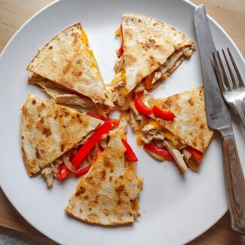 Sizzling skillet Chicken Quesadilla with melted cheddar and Monterey Jack oozing from crispy tortilla edges.