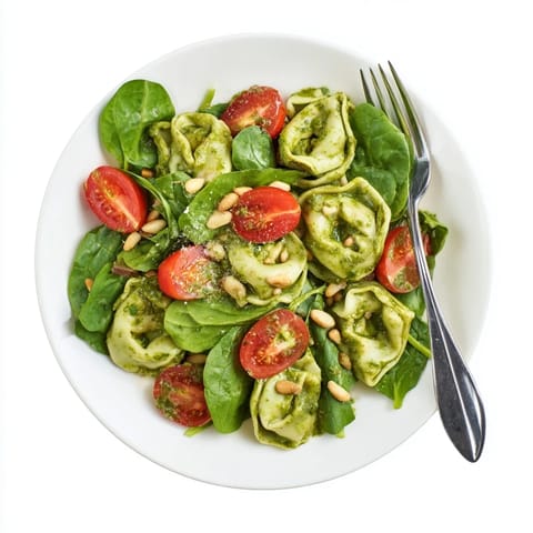 This easy pesto tortellini salad is served on a rustic plate, perfect for summer picnics.  