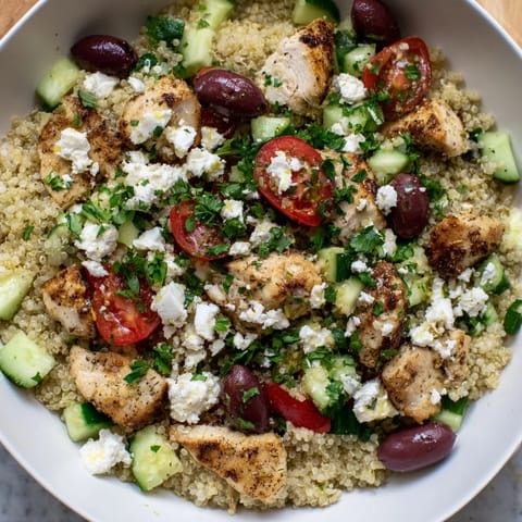 A vibrant Mediterranean Chicken Bowl features tender chicken, creamy feta, and crisp vegetables, all drizzled with a zesty lemon dressing.  