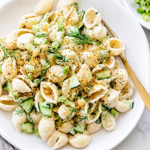 Bright green cucumbers and tender shell pasta glisten with creamy dressing in this refreshing Cucumber Crunch Pasta Salad, perfect for summer picnics. 