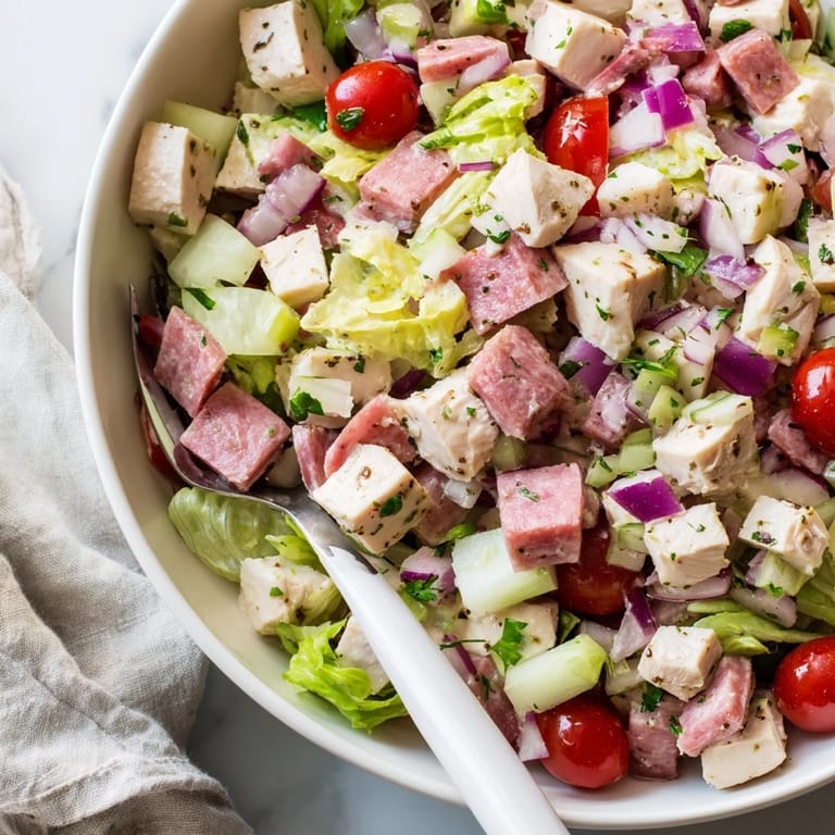 A hearty Italian Deli Chopped Chicken Salad tossed with pepperoncini, cherry tomatoes, and a zesty herb-packed dressing in a rustic bowl.