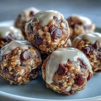 Close-up of Banana Chocolate Chip Energy Balls on a wooden cutting board, showing the soft, rolled texture of the no-bake snack with visible oats and chocolate chips.