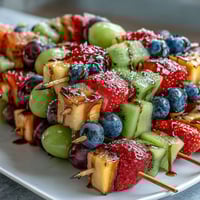 Rainbow fruit skewers with honey dip, a vibrant and healthy snack perfect for summer parties and gatherings.